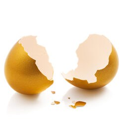 broken golden egg isolated on white background